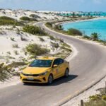 Coche amarillo moderno junto a las dunas de arena blanca de Cayo Guillermo