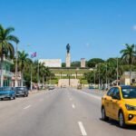 Coche amarillo moderno junto al monumento al Che Guevara en Santa Clara