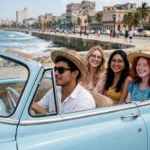 Turistas en un coche clásico azul claro descapotable recorriendo el Malecón de La Habana